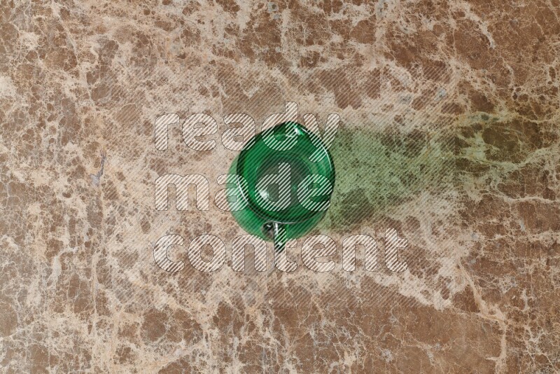 A colored glass jug on beige marble background