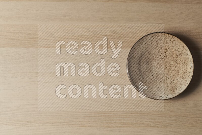 A multicolored pottery plate on light wooden background