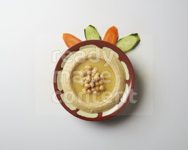 Hummus in a traditional plate garnished with roasted chickpeas  on a white background