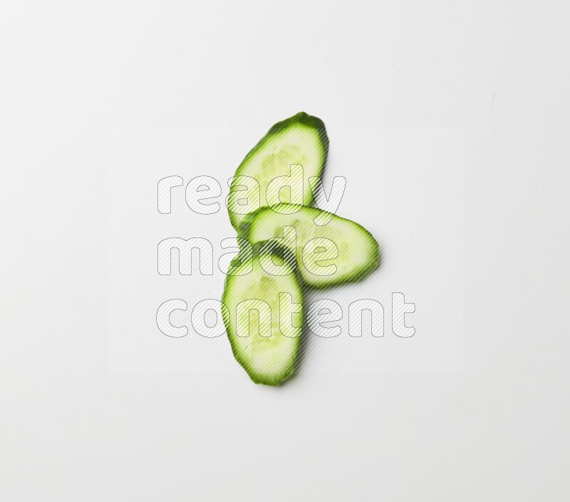 three cucumber slices on white background