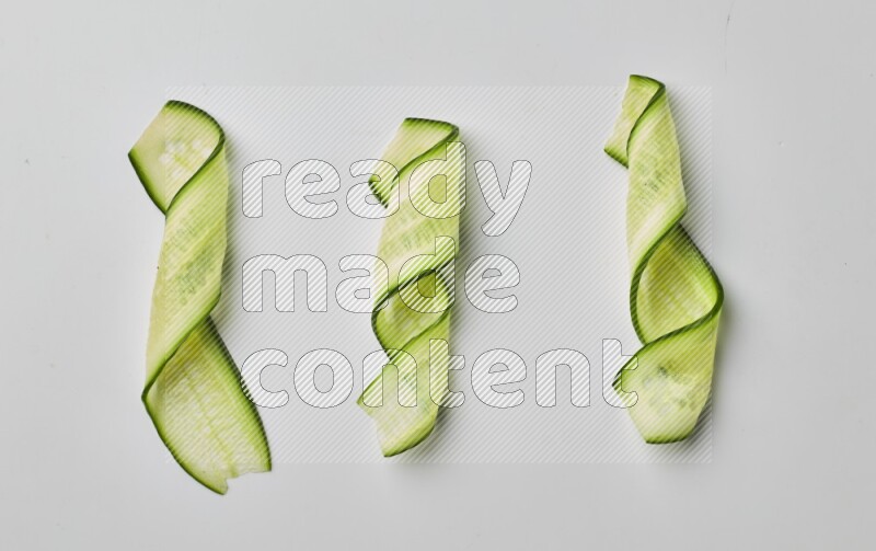 Three cucumber ribbons on a white background