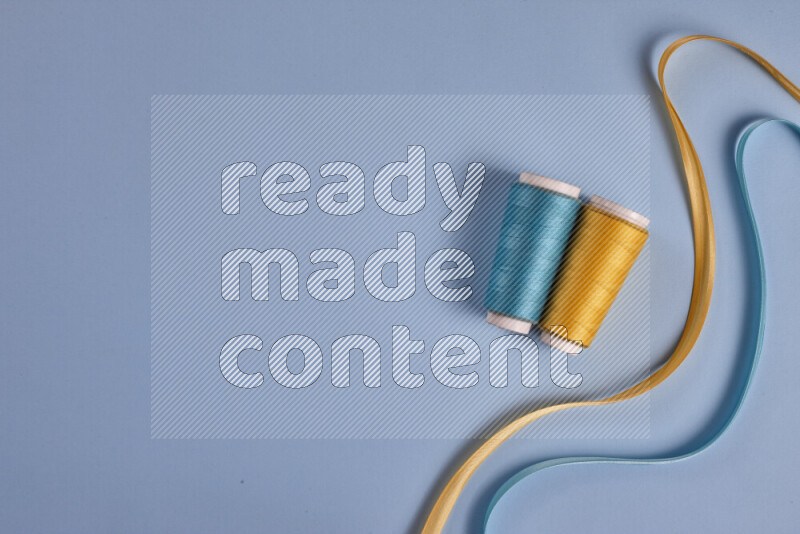 A yellow and blue collection of sewing and tailoring tools arranged on a blue background