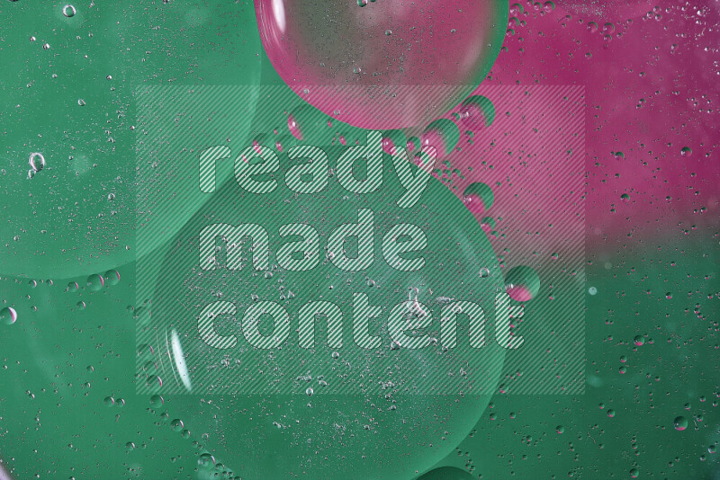 لقطات مقربة لفقاعات من الزيت على سطح الماء باللون الأخضر والوردي