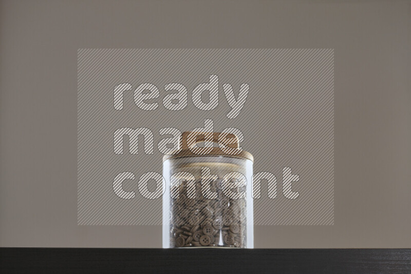 أزرار متنوعة في وعاء زجاجي علي خلفية سوداء