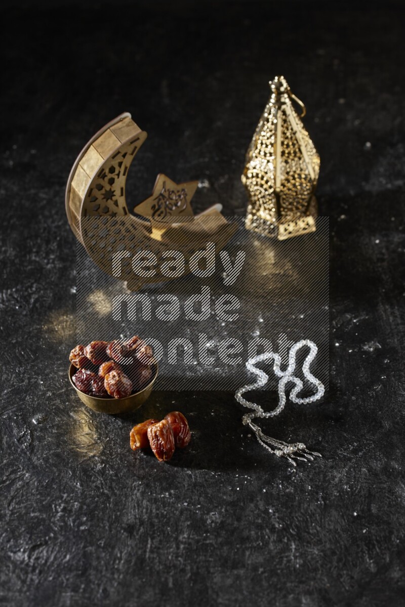 تمر في وعاء معدني مع سبحة بجانب فوانيس ذهبية علي خلفية سوداء