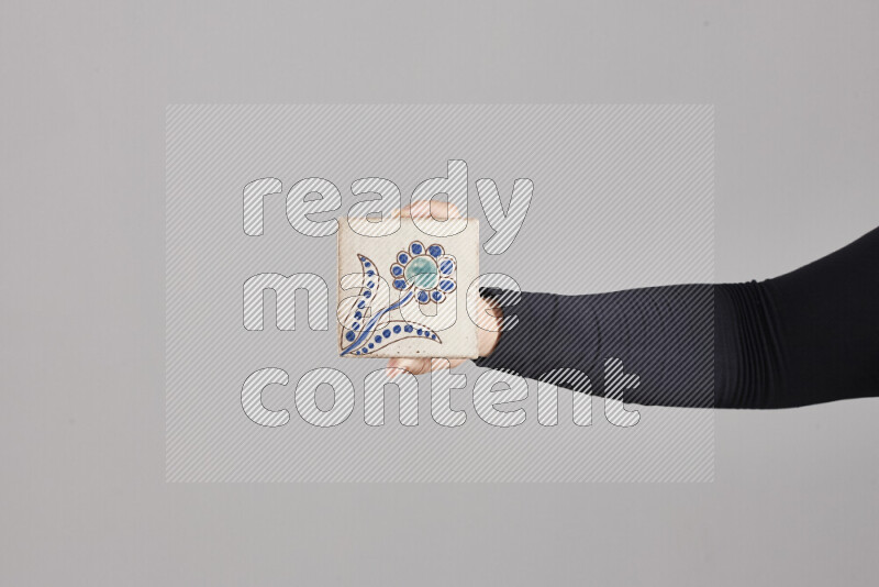 A woman in black abaya holding different pottery essentials in different positions