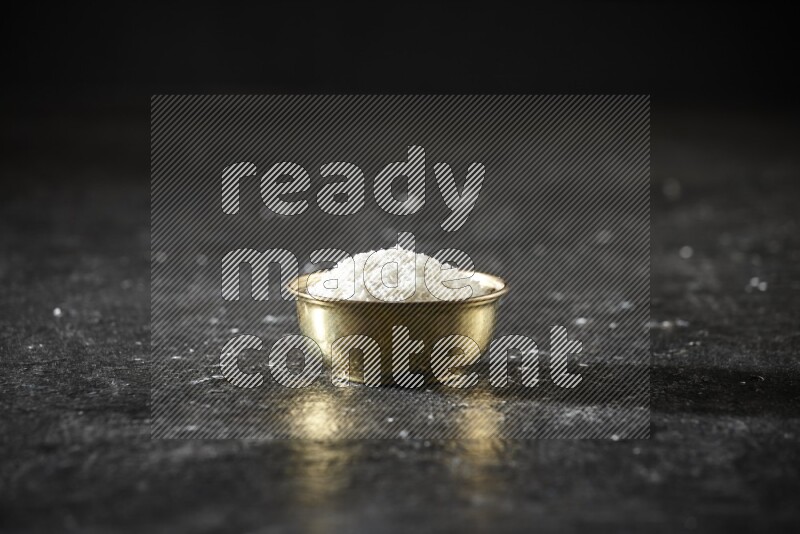 Dried fruits in a metal bowl in a dark setup