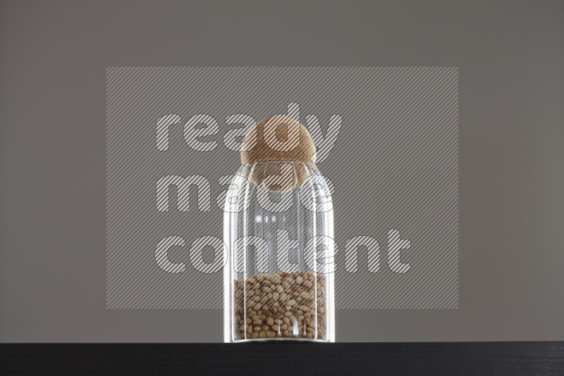 Black-eyed peas in a glass jar on black background