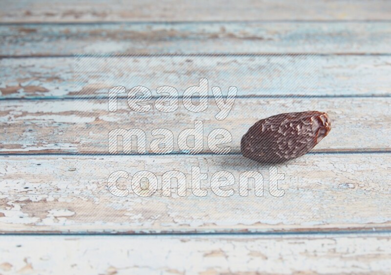 one madjoul date on a light blue wooden background