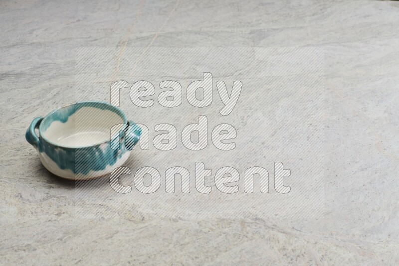 A multicolored pottery bowl on grey marble background
