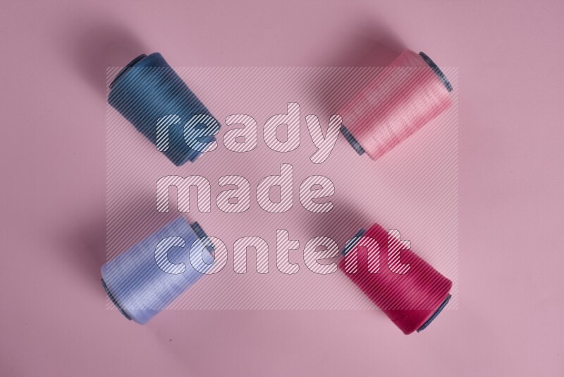 A blue collection of sewing and tailoring tools arranged on a pink background