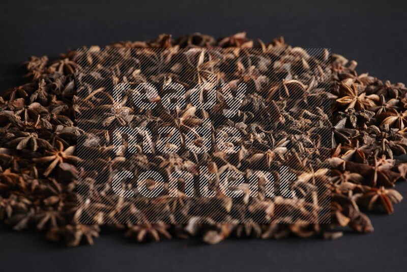 Star Anise herbs fill the frame on black flooring