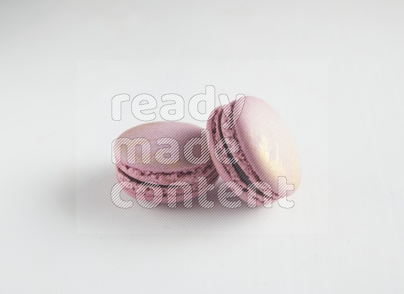45º Shot of two Purple Strawberry macarons on white background