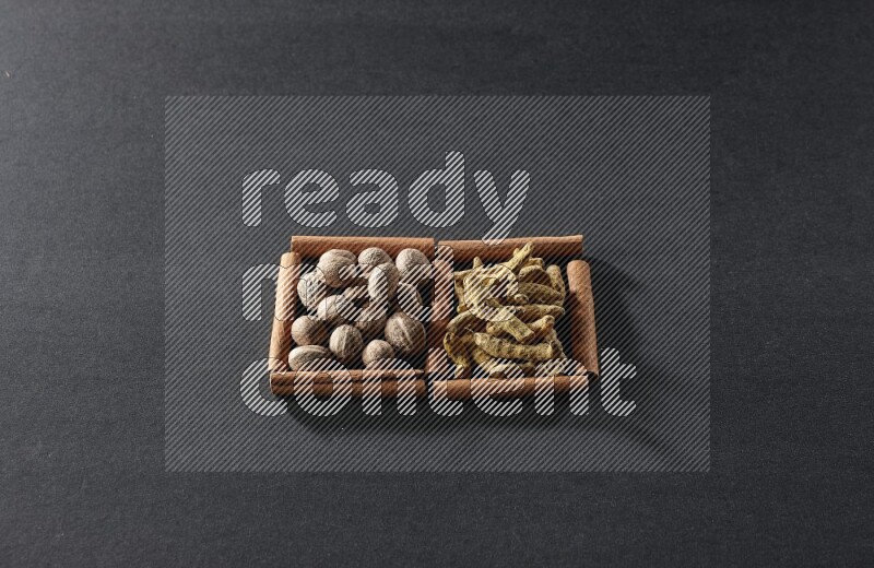 2 squares of cinnamon sticks full of nutmeg and turmeric fingers on black flooring