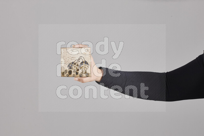 A woman in black abaya holding different pottery essentials in different positions