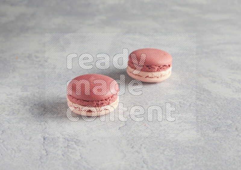 45º Shot of two Pink Litchi Raspberry macarons  on white  marble background