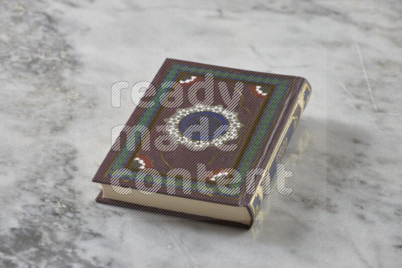 Quran with a prayer beads on grey marble background