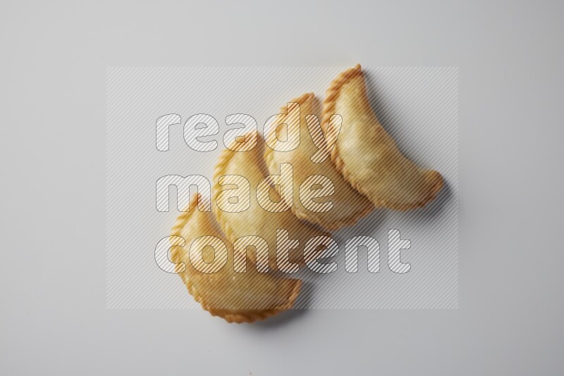 Four fried sambosa from a top angle on a white background