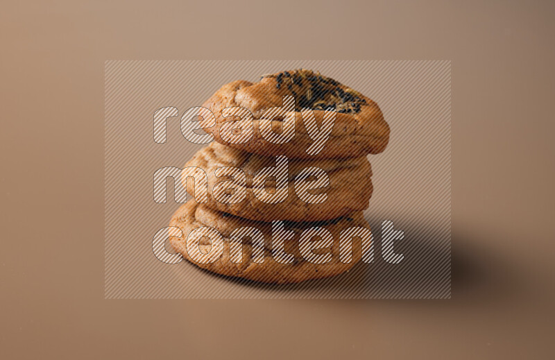 Hasawi cookies field with date and decorated by black seed and Anise grain on a brown background
