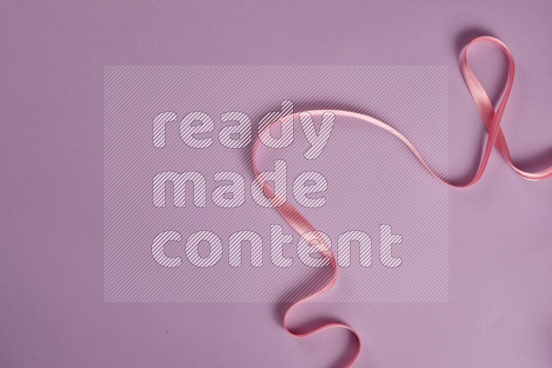 A pink and purple collection of sewing and tailoring tools arranged on a purple background