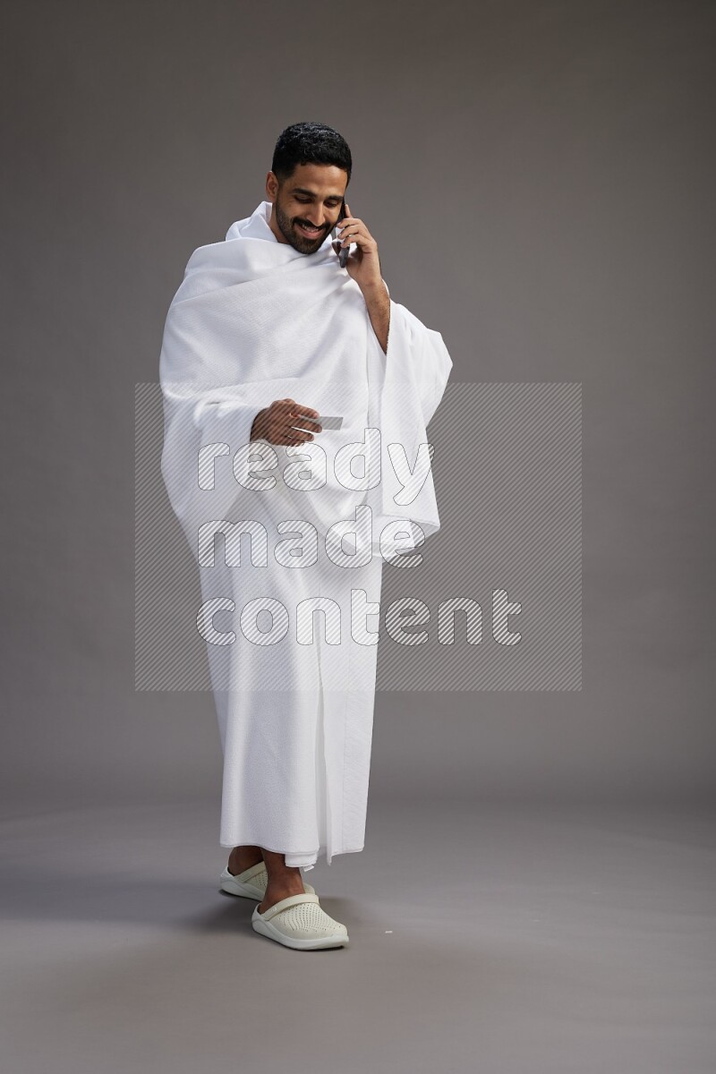 A man wearing Ehram Standing holding ATM card on gray background