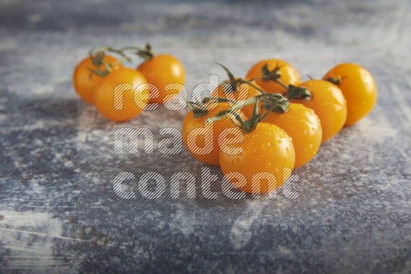 yellow cherry tomato vein on a textured rusty blue background 45 degree