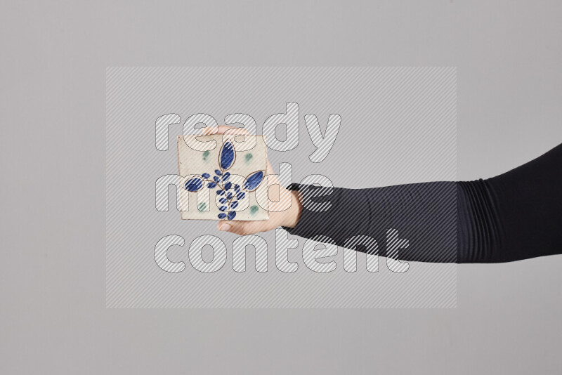A woman in black abaya holding different pottery essentials in different positions