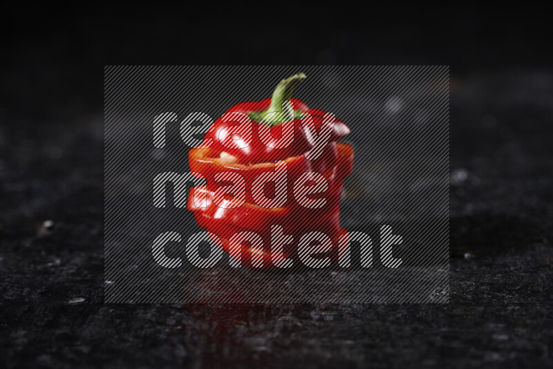 Red bell pepper slices on black background