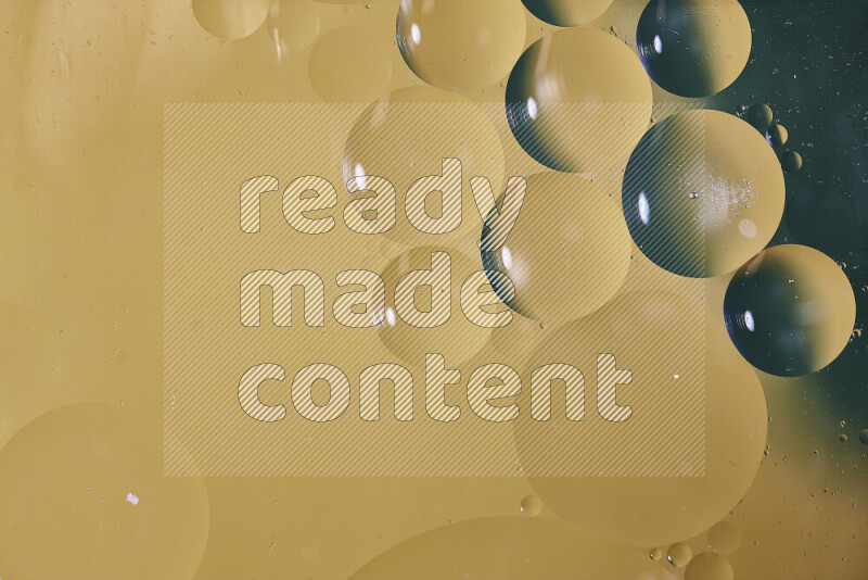 Close-ups of abstract oil bubbles on water surface in shades of green and yellow