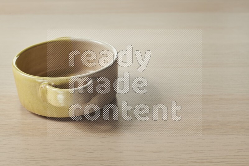A multicolored pottery bowl on light wooden background