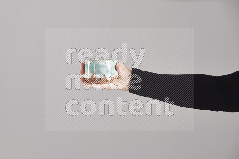 A woman in black abaya holding different pottery essentials in different positions