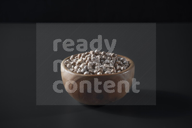 Chickpeas in a wooden bowl on grey background