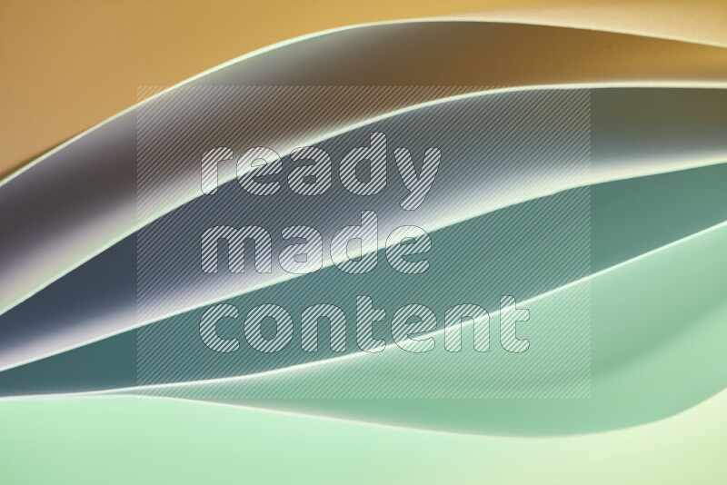 This image showcases an abstract paper art composition with paper curves in green and orange gradients created by colored light