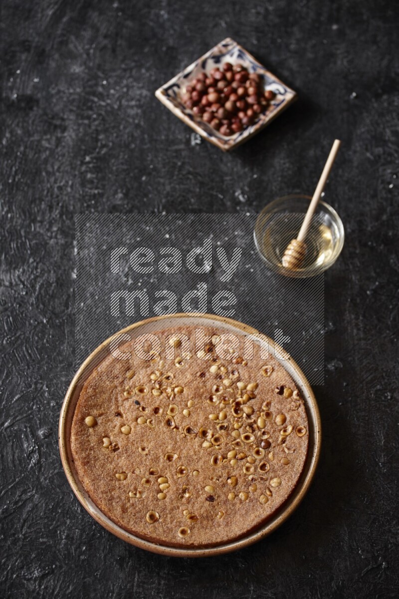 Basbousa with nuts and honey in a dark setup
