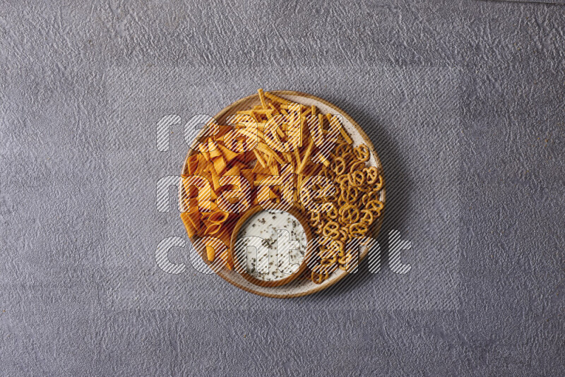 Assorted snacks in pottery bowls on grey background