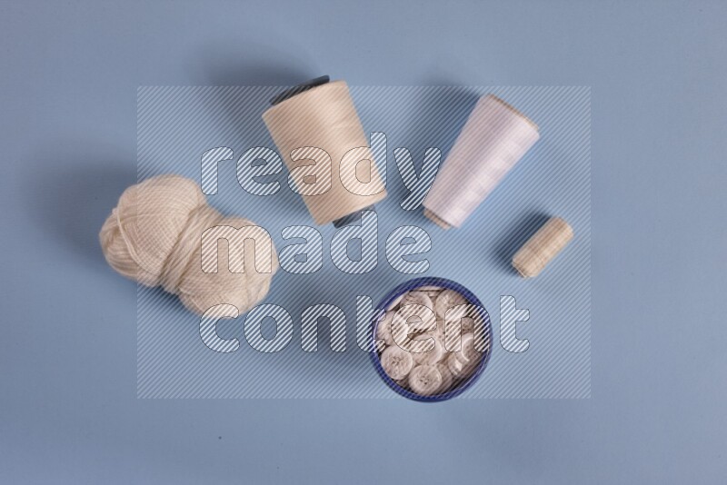 مجموعة من أدوات الخياطة والتفصيل بيضاء اللون على خلفية زرقاء