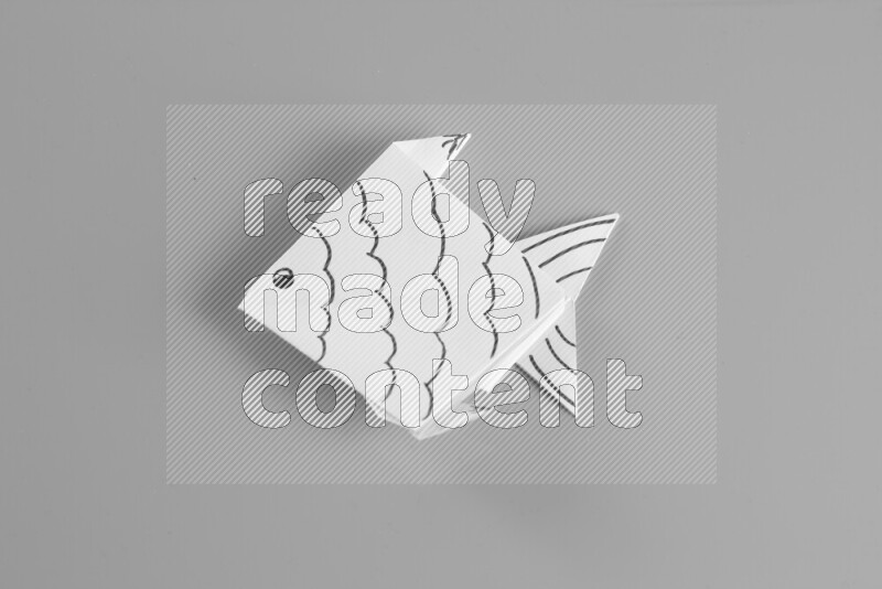 Origami fish on grey background