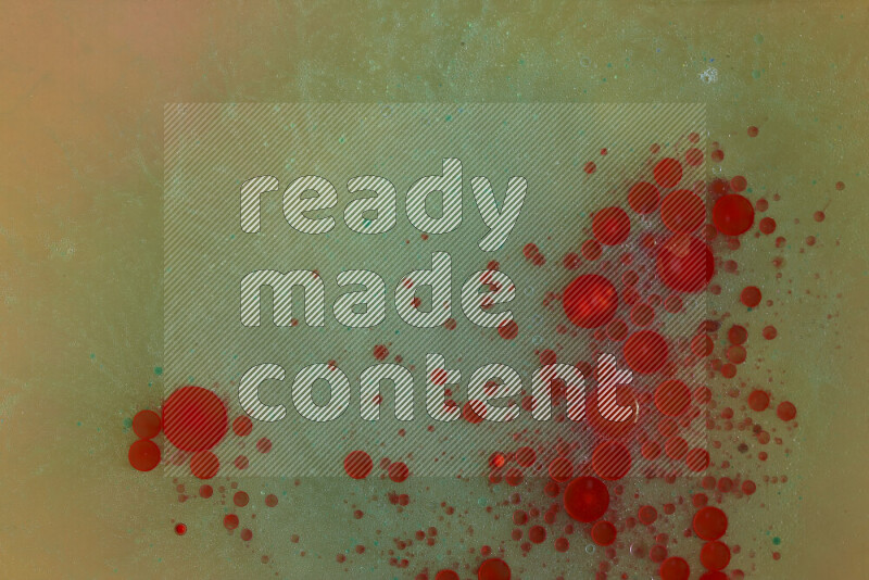 The image captures a dramatic splatter of red, green and yellow paints over the backdrop