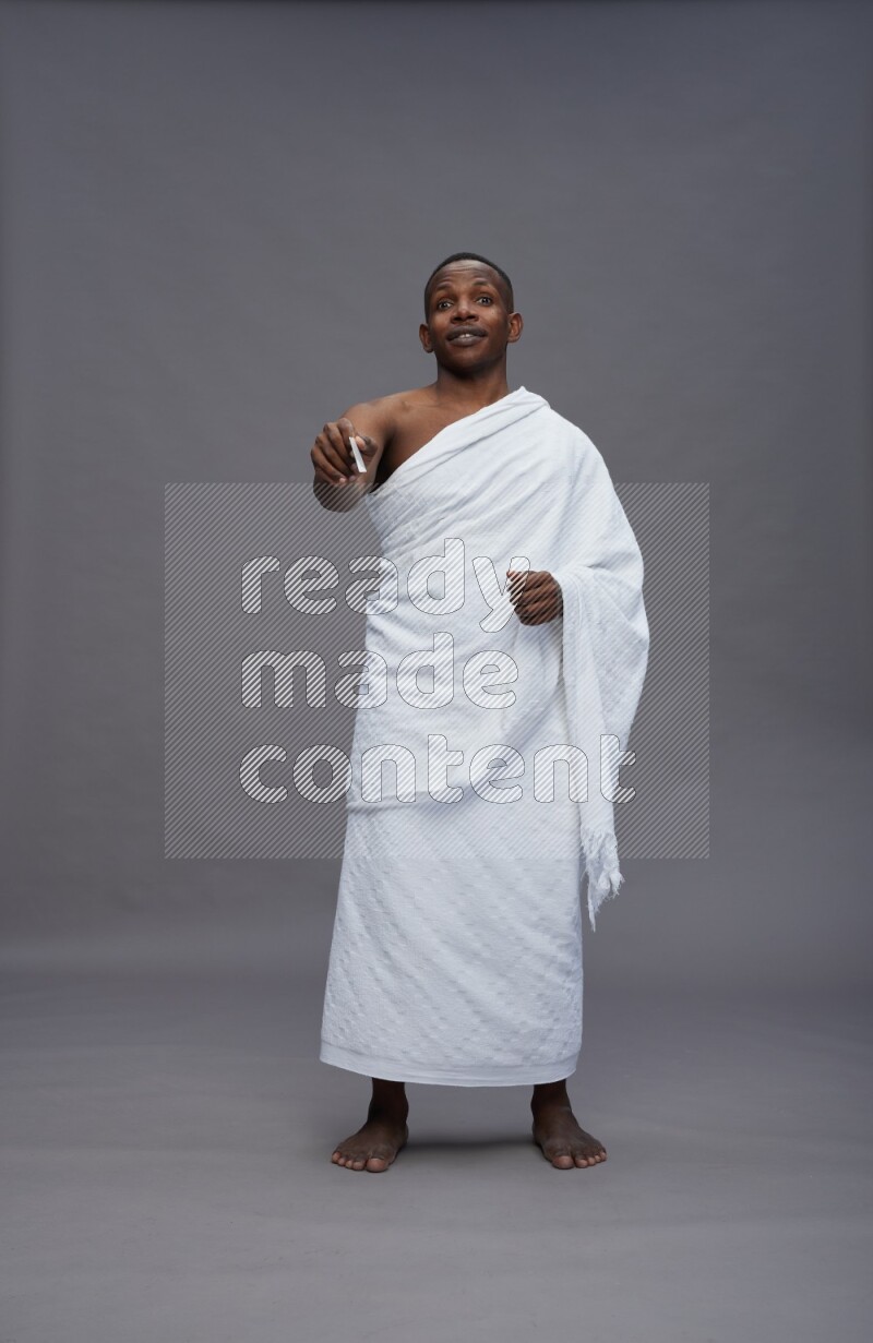 A man wearing Ehram Standing holding ATM card on gray background