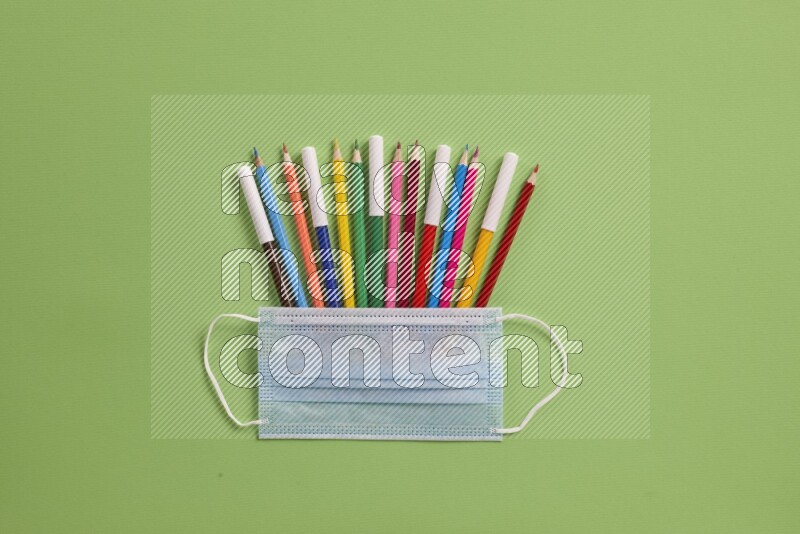 Different school supplies on green background