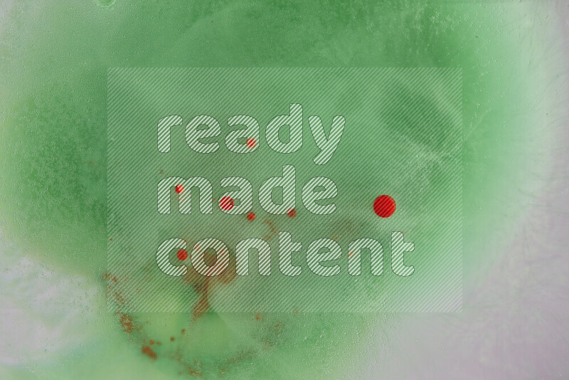 The image captures a dramatic splatter of red paint over a green backdrop