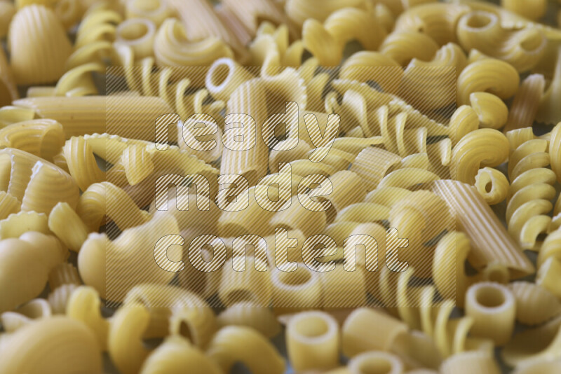 Different pasta types on light blue background