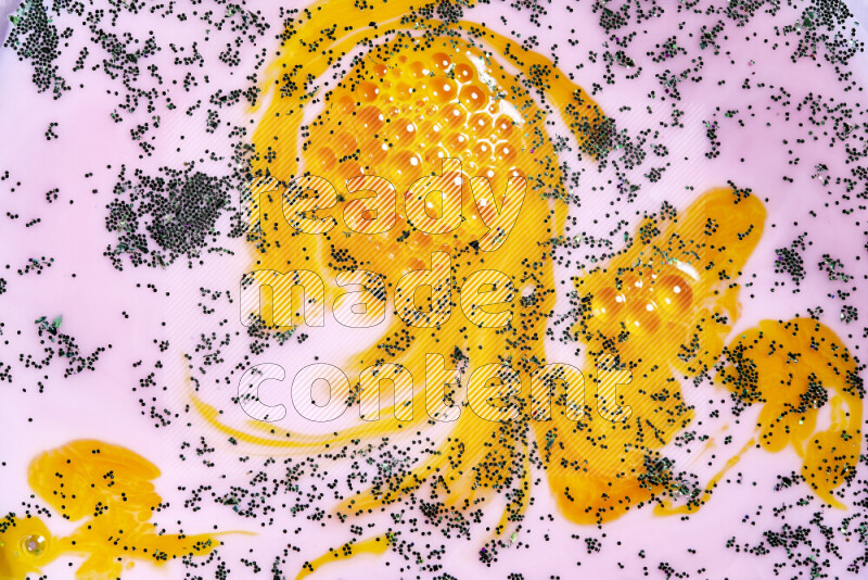 لقطة مقربة لبريق أخضر متلألئ منتشر على خلفية من اللون الأصفر والوردي في حركات دائرية