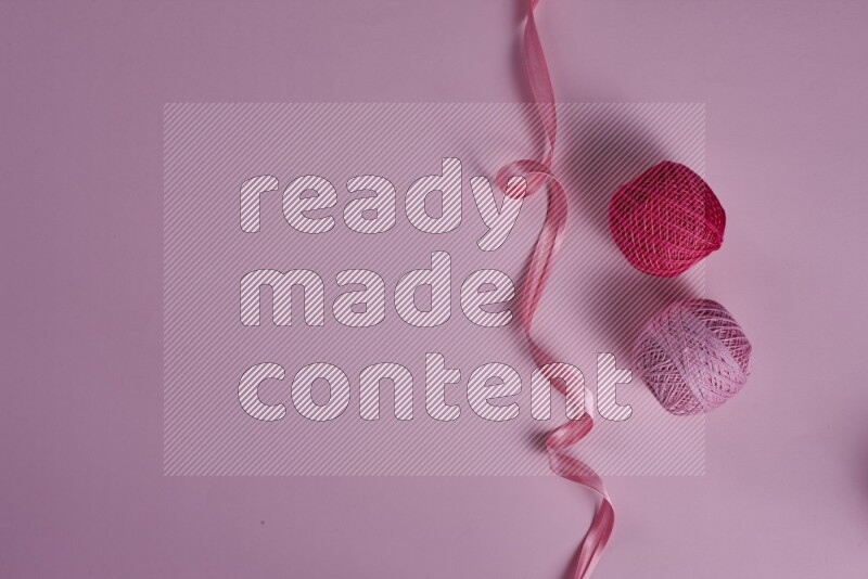 A pink collection of sewing and tailoring tools arranged on a pink background