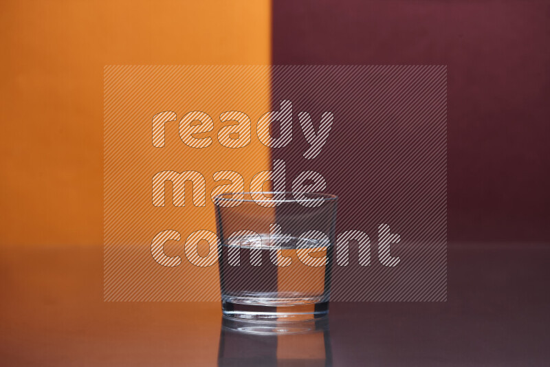 The image features a clear glassware filled with water, set against orange and dark red background