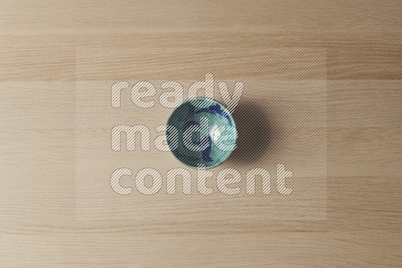 A decorative pottery bowl on light wooden background