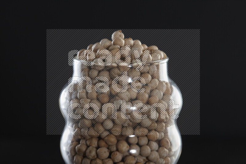 Chickpeas in a glass jar on black background