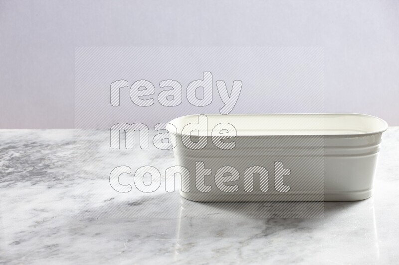 An empty white plant pot on grey marble background