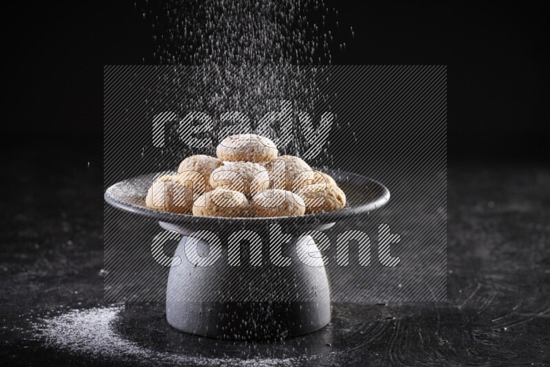 Kahk on a serving plate on a black background
