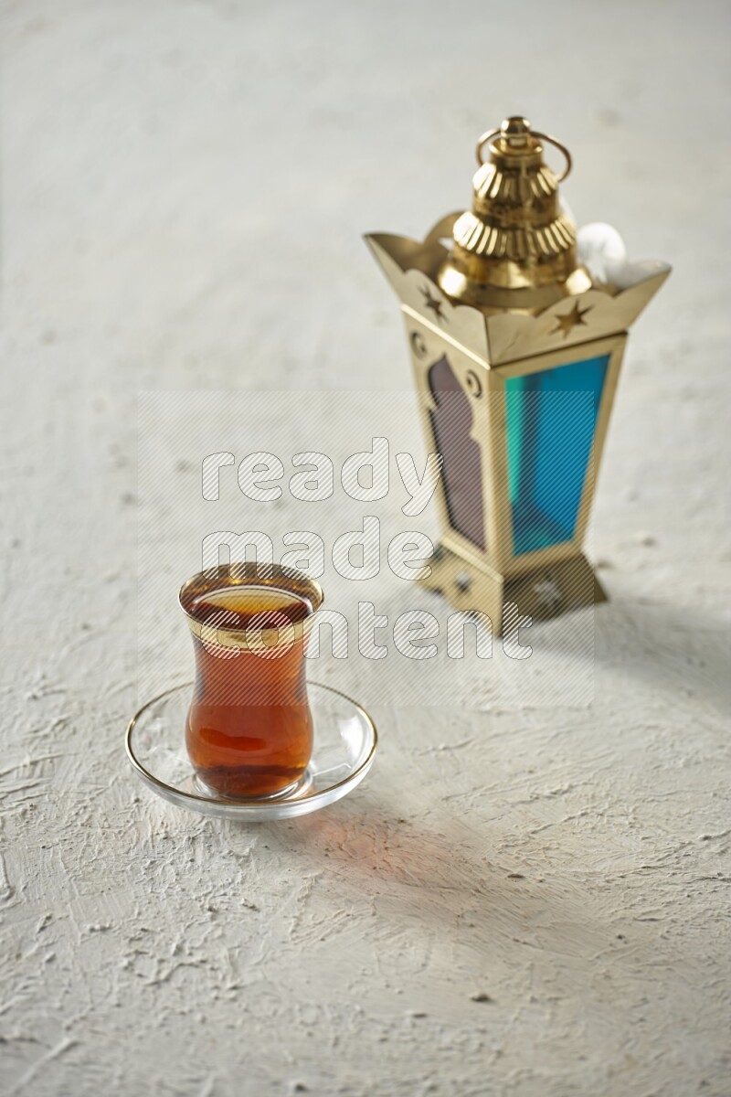 A golden lantern with different drinks, dates, nuts, prayer beads and quran on textured white background